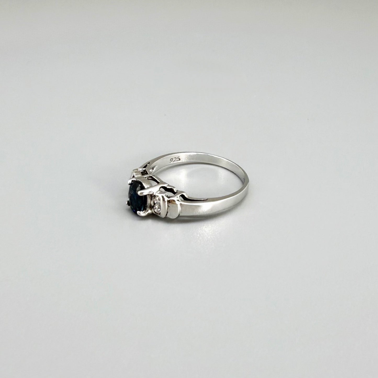Sapphire and CZ ring in white gold plated sterling silver on neutral background