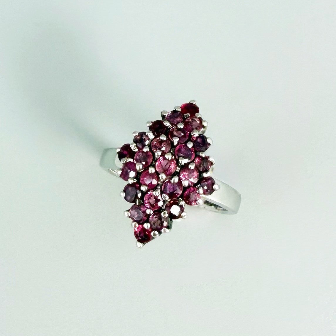 Ruby cluster ring in white gold plated sterling silver, featuring multiple faceted natural rubies in geometric design, elegant and radiant look.