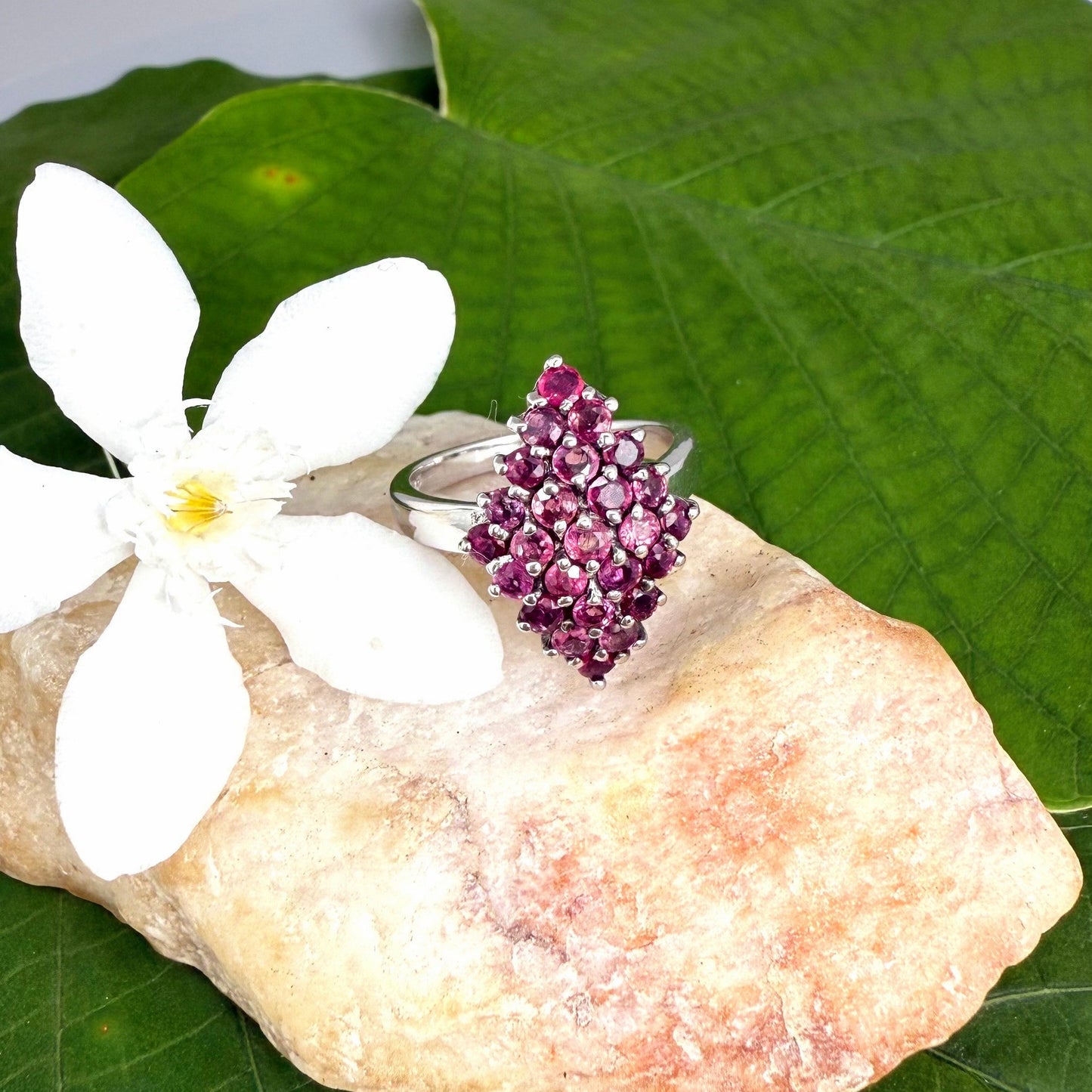 Ruby cluster ring in white gold plated sterling silver, featuring multiple faceted natural rubies in geometric design, elegant and radiant look.