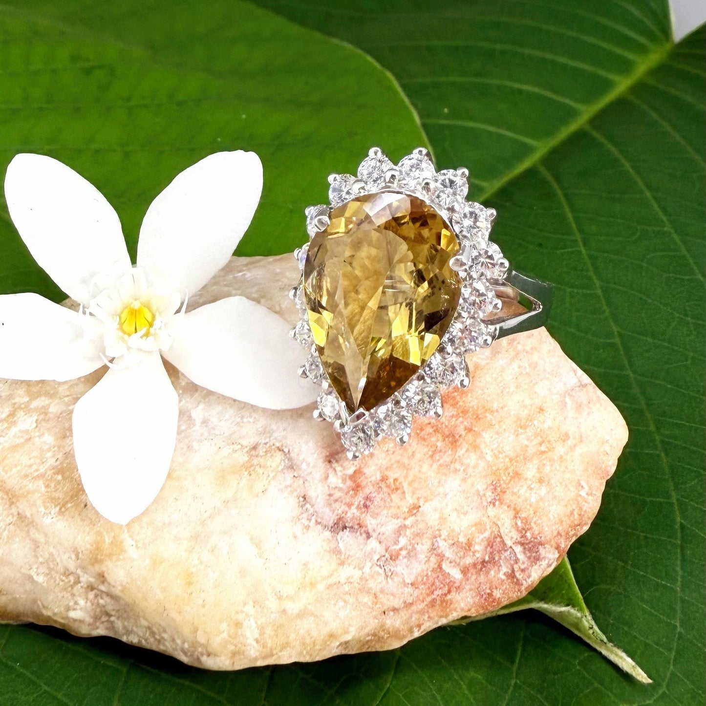 Citrine and CZ ring in white gold plated sterling silver, featuring a pear-shaped golden-yellow gemstone surrounded by clear cubic zirconia halo, elegant and refined design