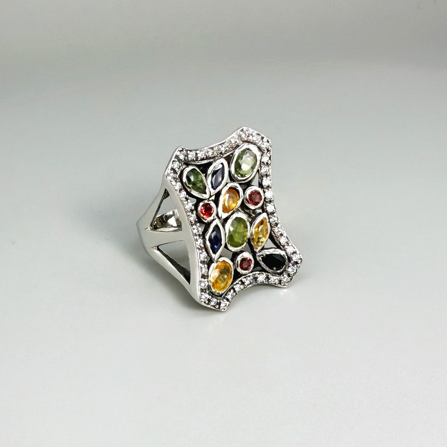 Multigemstone ring in white gold plated sterling silver, featuring sapphires, topaz, tourmalines and spinels in geometric design, colorful and elegant.