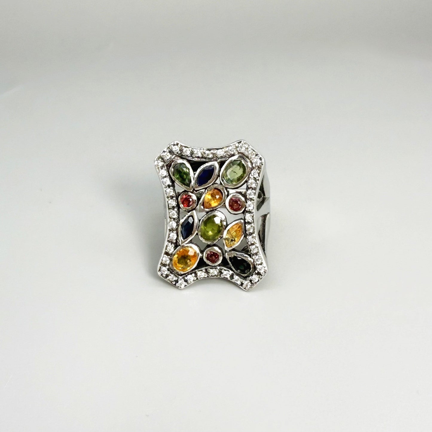 Multigemstone ring in white gold plated sterling silver, featuring sapphires, topaz, tourmalines and spinels in geometric design, colorful and elegant.
