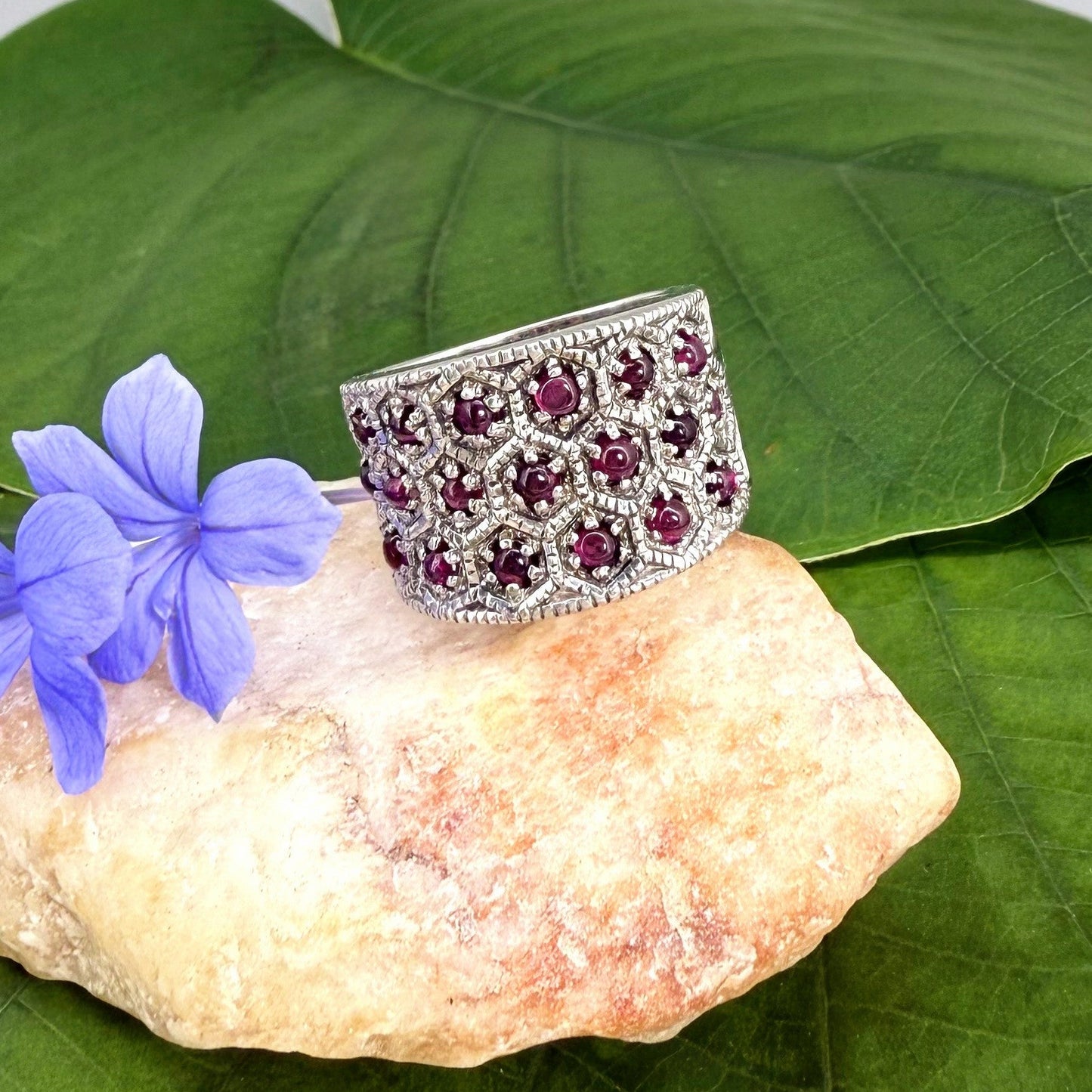 Rhodolite band ring in white gold plated sterling silver, featuring faceted rose-violet gemstones in a wide design, elegant and feminine style.