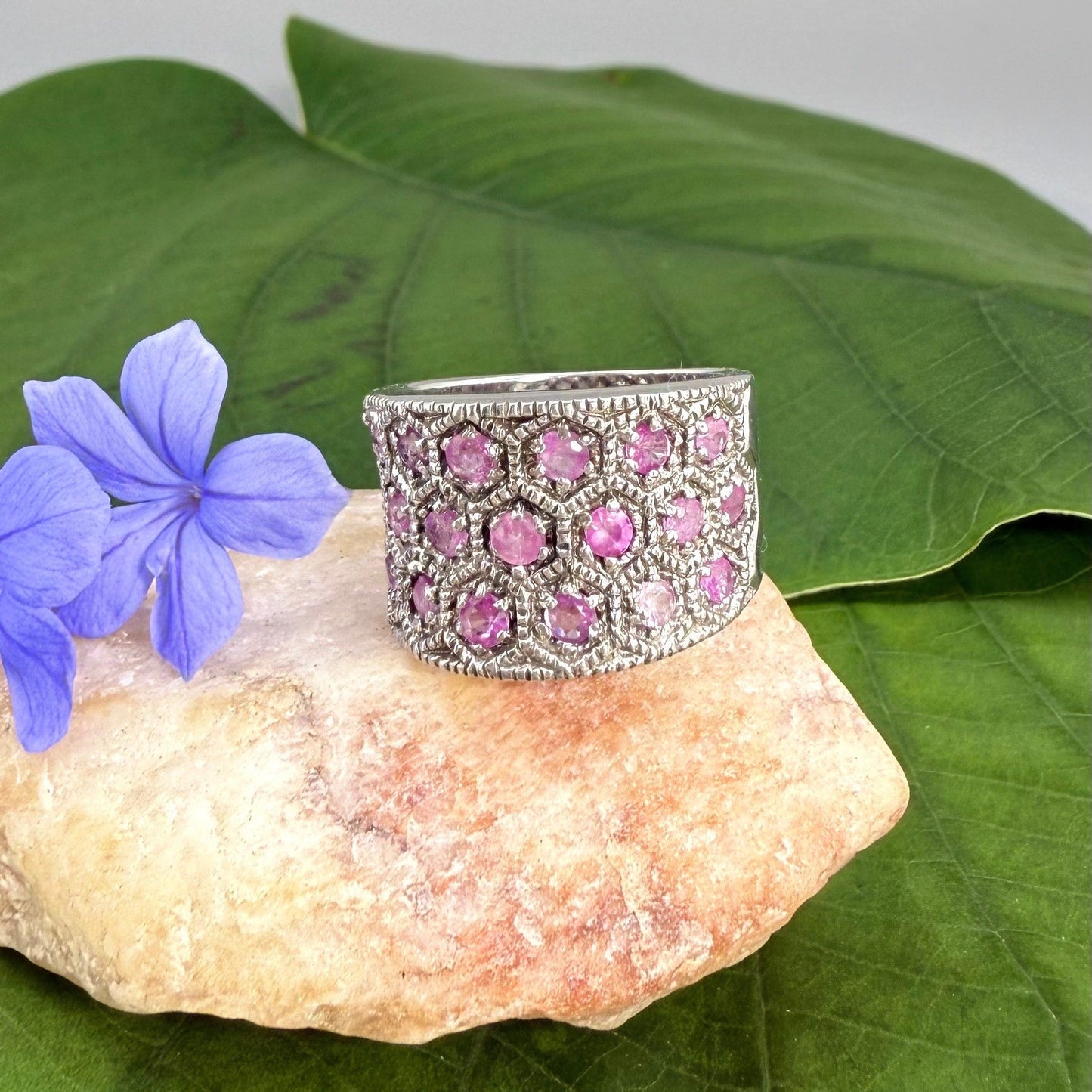 Ruby band ring in white gold plated sterling silver, featuring faceted natural red gemstones in a wide band design, elegant and luxurious style.