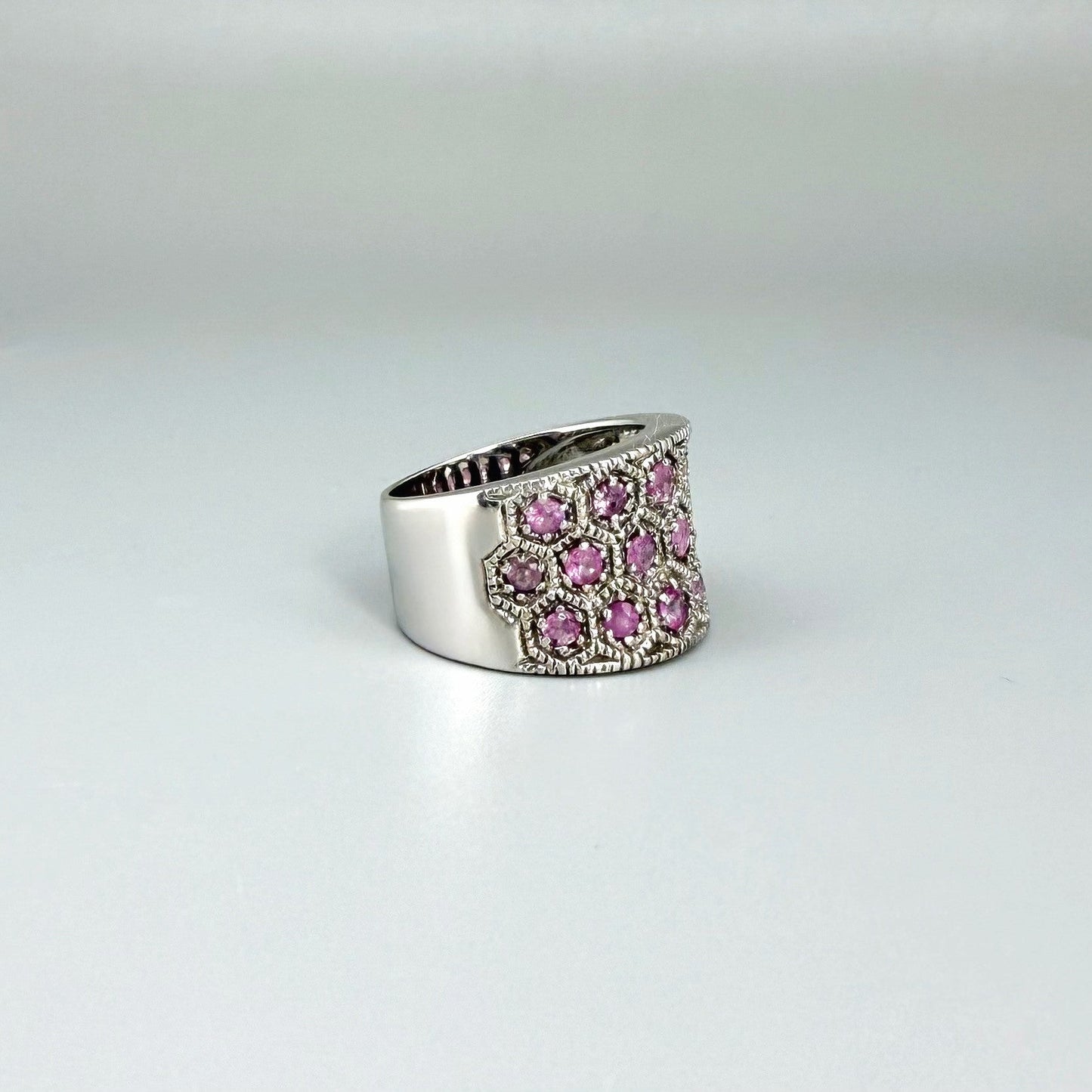 Ruby band ring in white gold plated sterling silver, featuring faceted natural red gemstones in a wide band design, elegant and luxurious style.