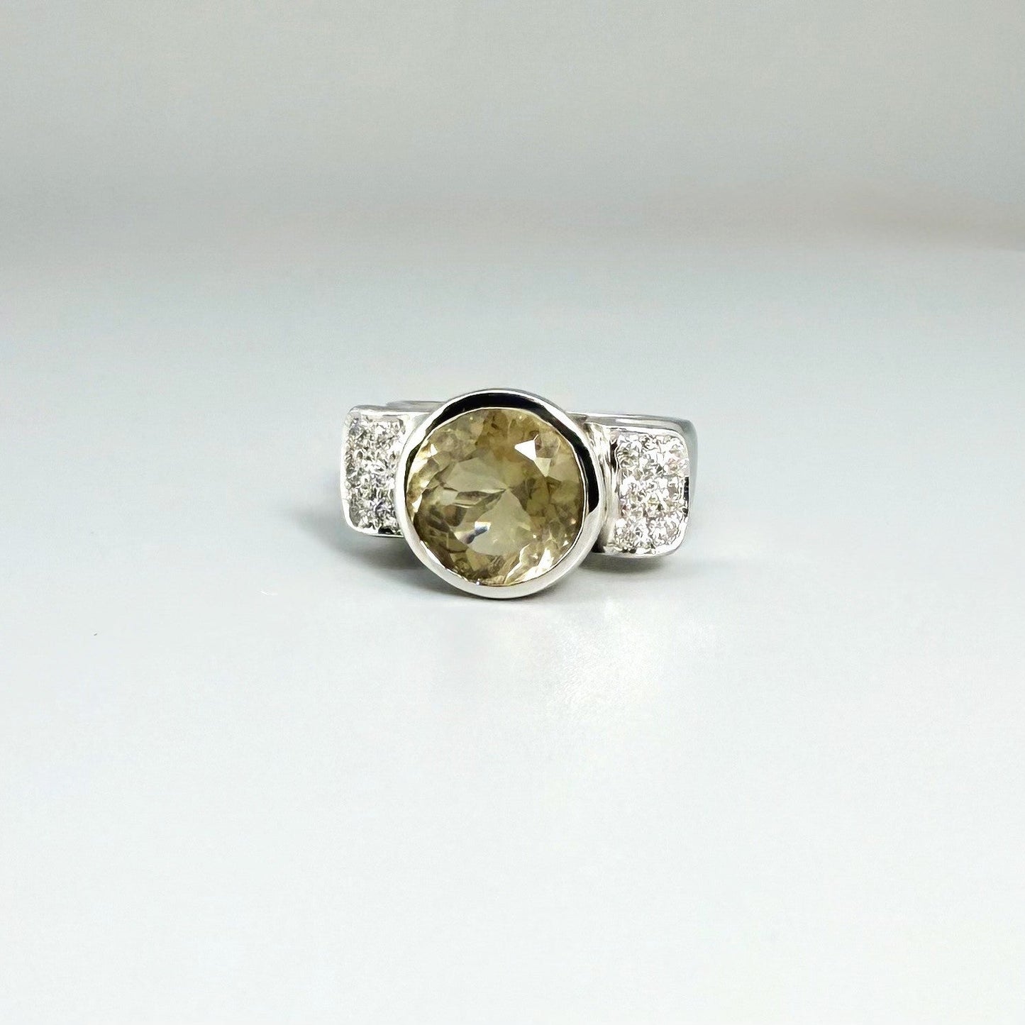 Citrine and CZ ring in white gold plated sterling silver, featuring a faceted golden gemstone with sparkling accents along the band, elegant and radiant design.