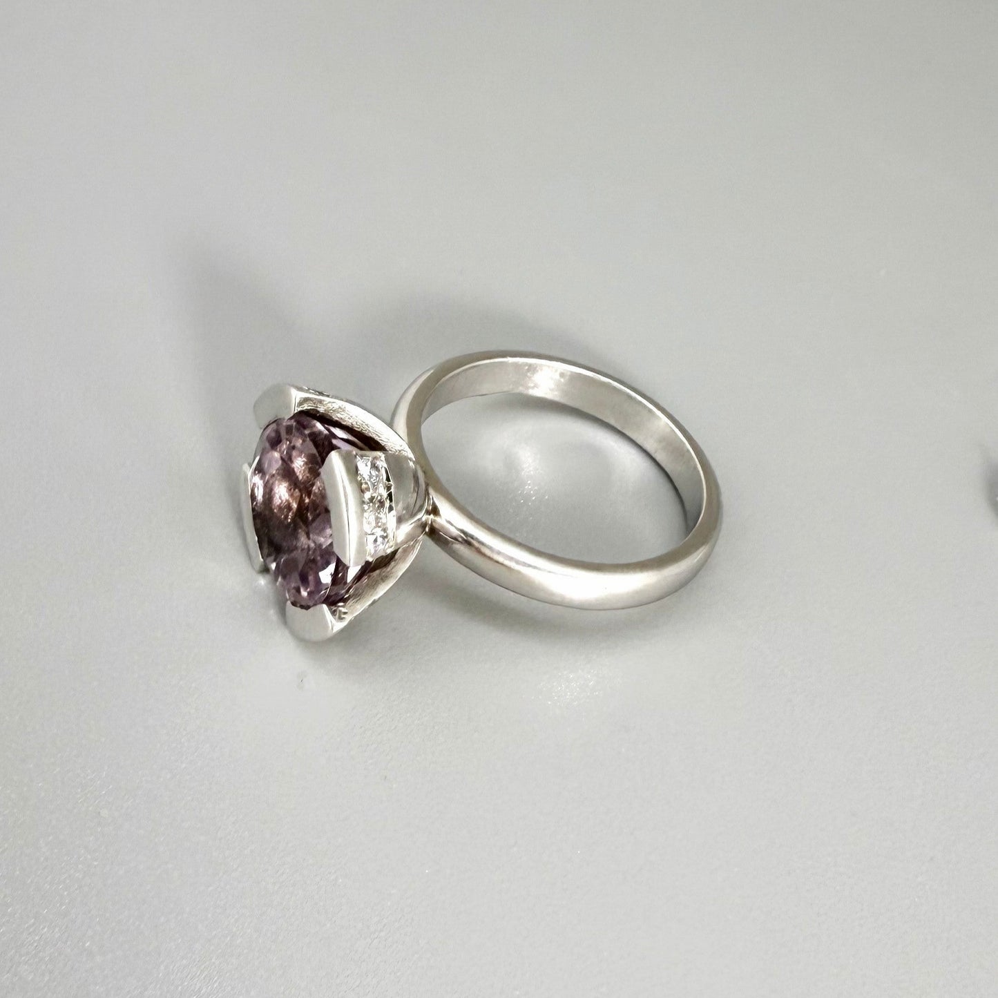 Close-up of amethyst ring showing violet gemstone and sparkling cubic zirconia accents