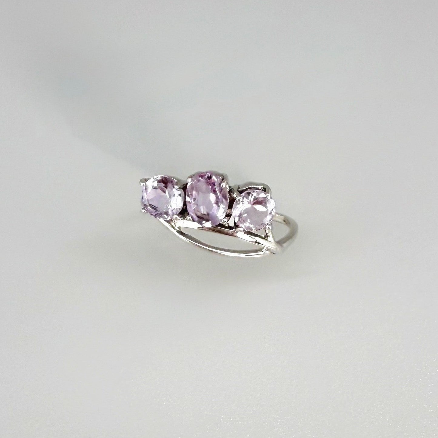 Three-stone amethyst ring in white gold plated sterling silver, featuring natural violet gemstones with soft lavender brilliance, elegant and feminine design.