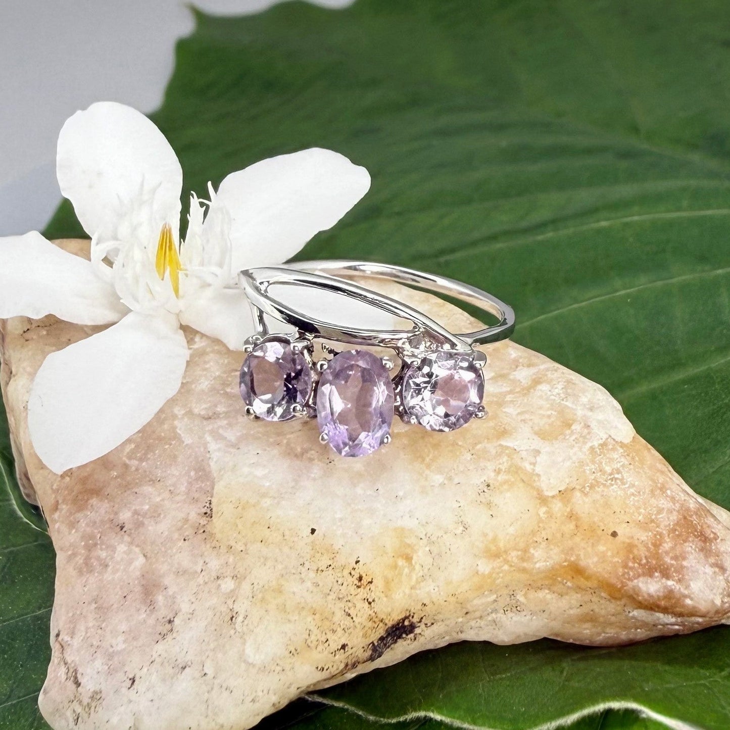 Three-stone amethyst ring in white gold plated sterling silver, featuring natural violet gemstones with soft lavender brilliance, elegant and feminine design.