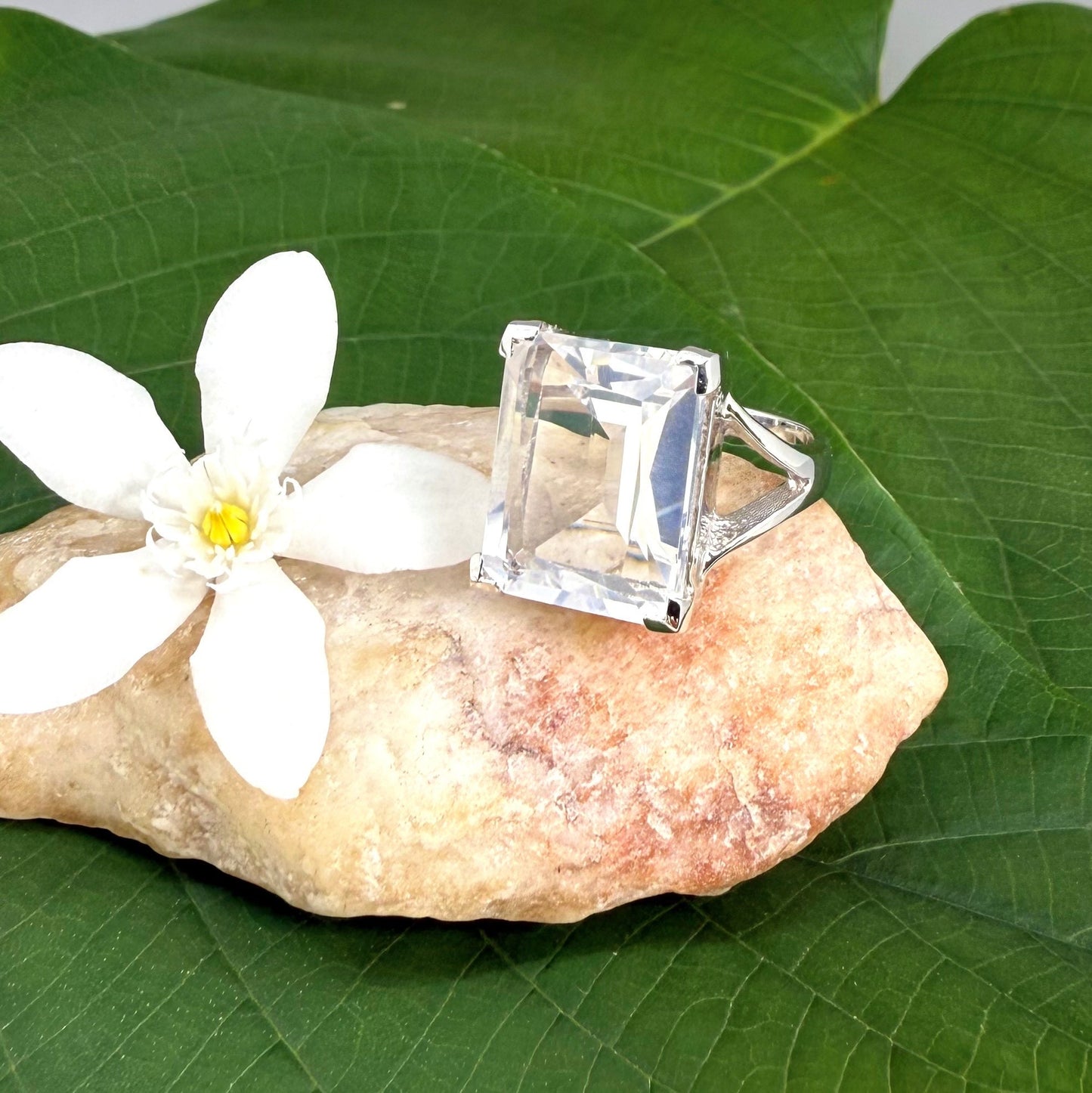 White quartz ring in white gold plated sterling silver, featuring a faceted clear gemstone with brilliant reflections, elegant and timeless design.