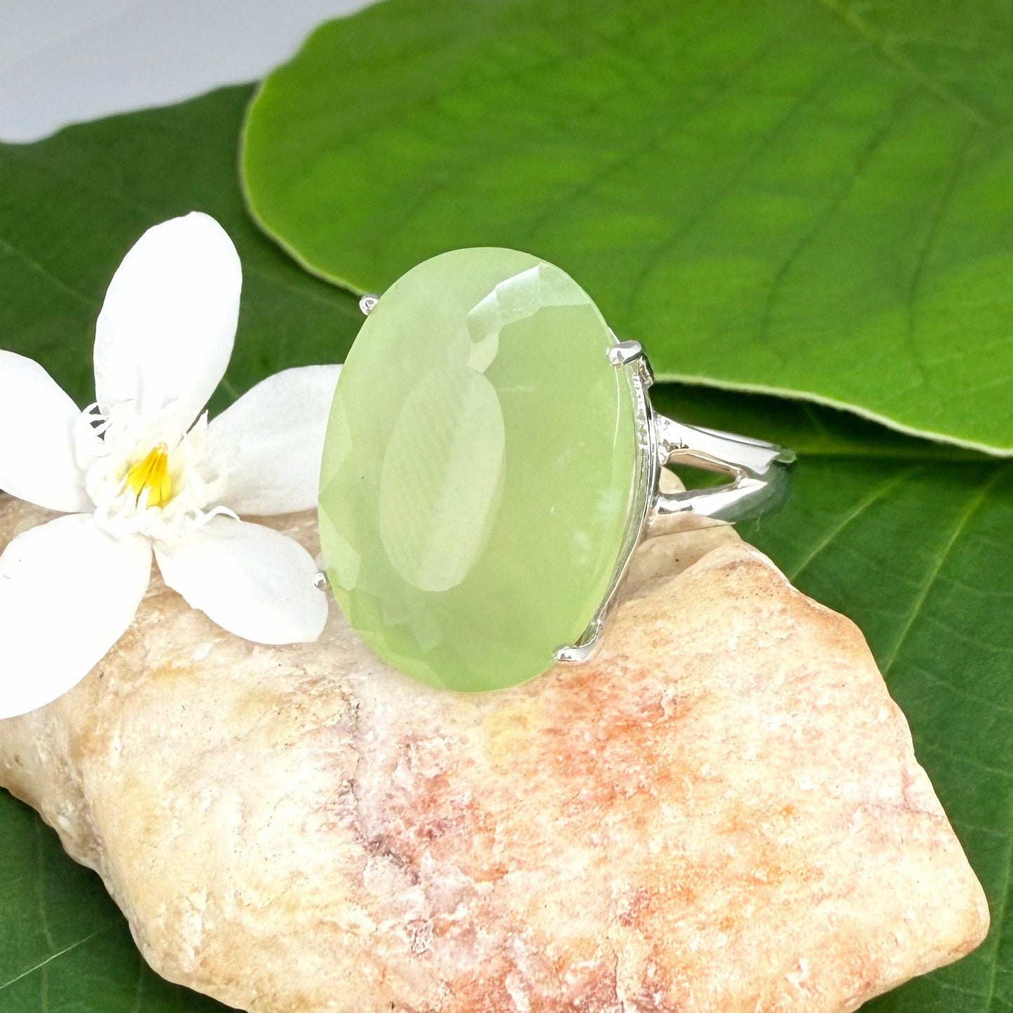 Chrysoprase ring in white gold plated sterling silver featuring an oval cabochon gemstone with light apple-green hue and smooth, natural translucence.