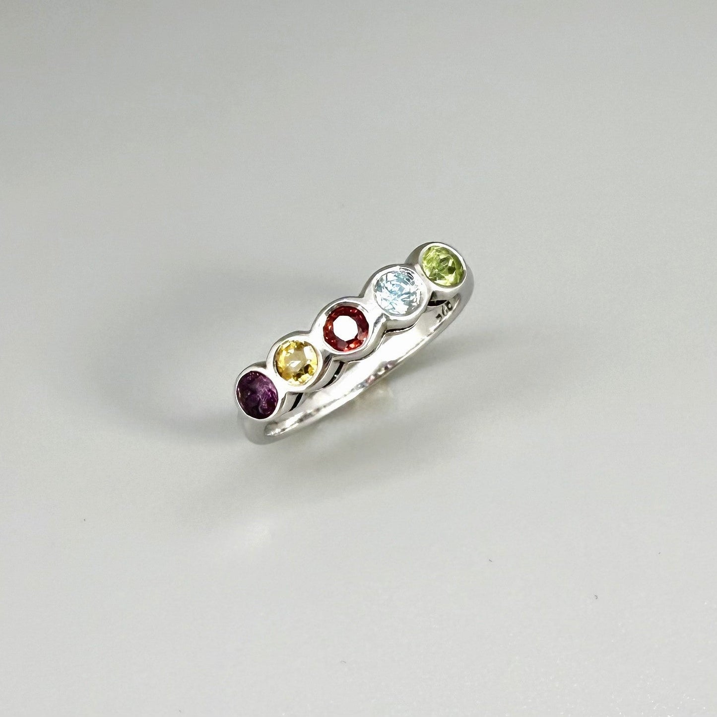 Multicolor gemstone ring in white gold plated sterling silver featuring citrine, tourmaline, rhodolite, and topaz, elegant band design with warm and cool tones.