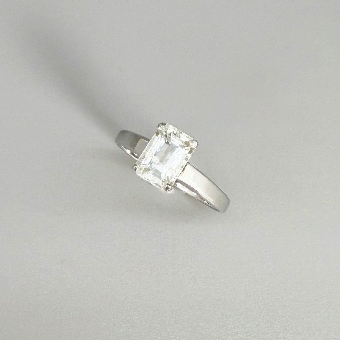 Aquamarine solitaire ring in white gold plated sterling silver, featuring a light blue natural gemstone on neutral background, elegant and timeless design.