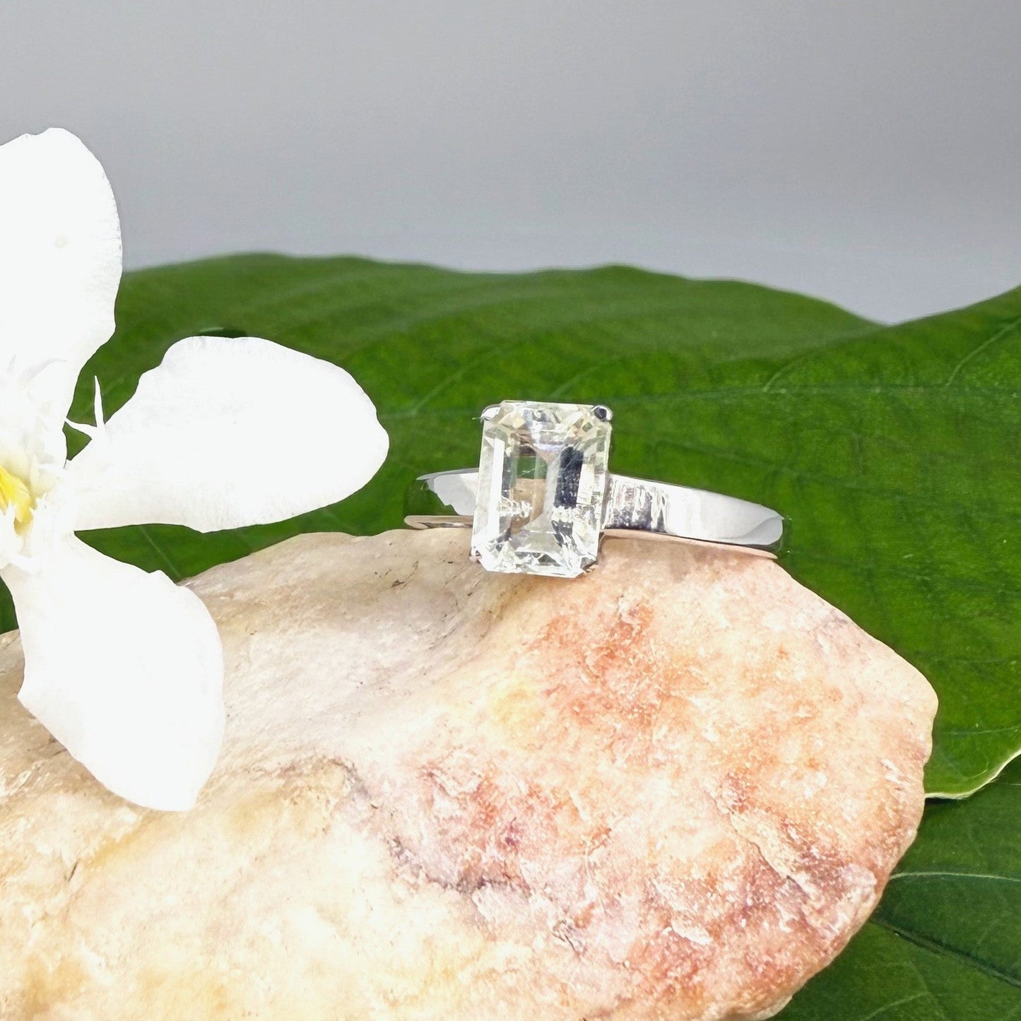 Aquamarine solitaire ring in white gold plated sterling silver, featuring a light blue natural gemstone on neutral background, elegant and timeless design.