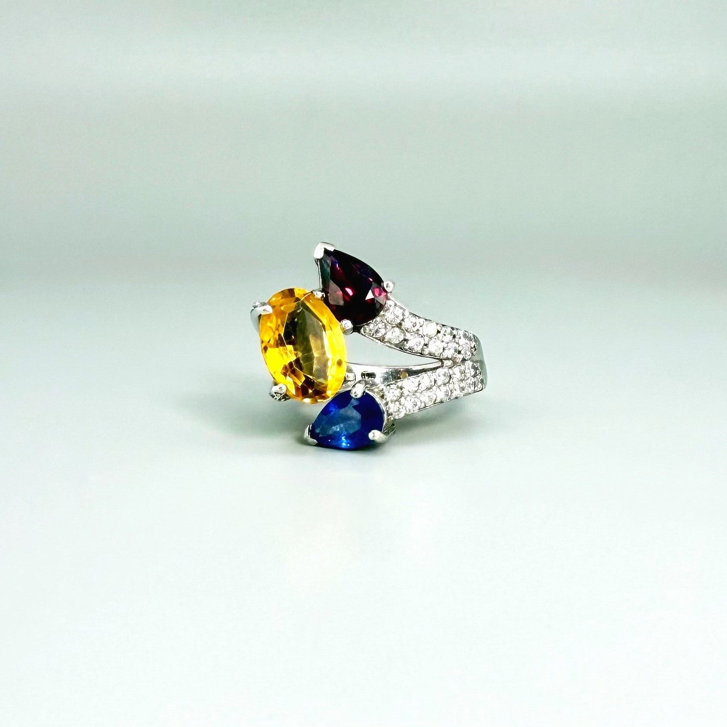 Sapphire, citrine, and rhodolite ring in white gold plated sterling silver, framed with sparkling cubic zirconia, featuring vivid natural gemstones in elegant design.