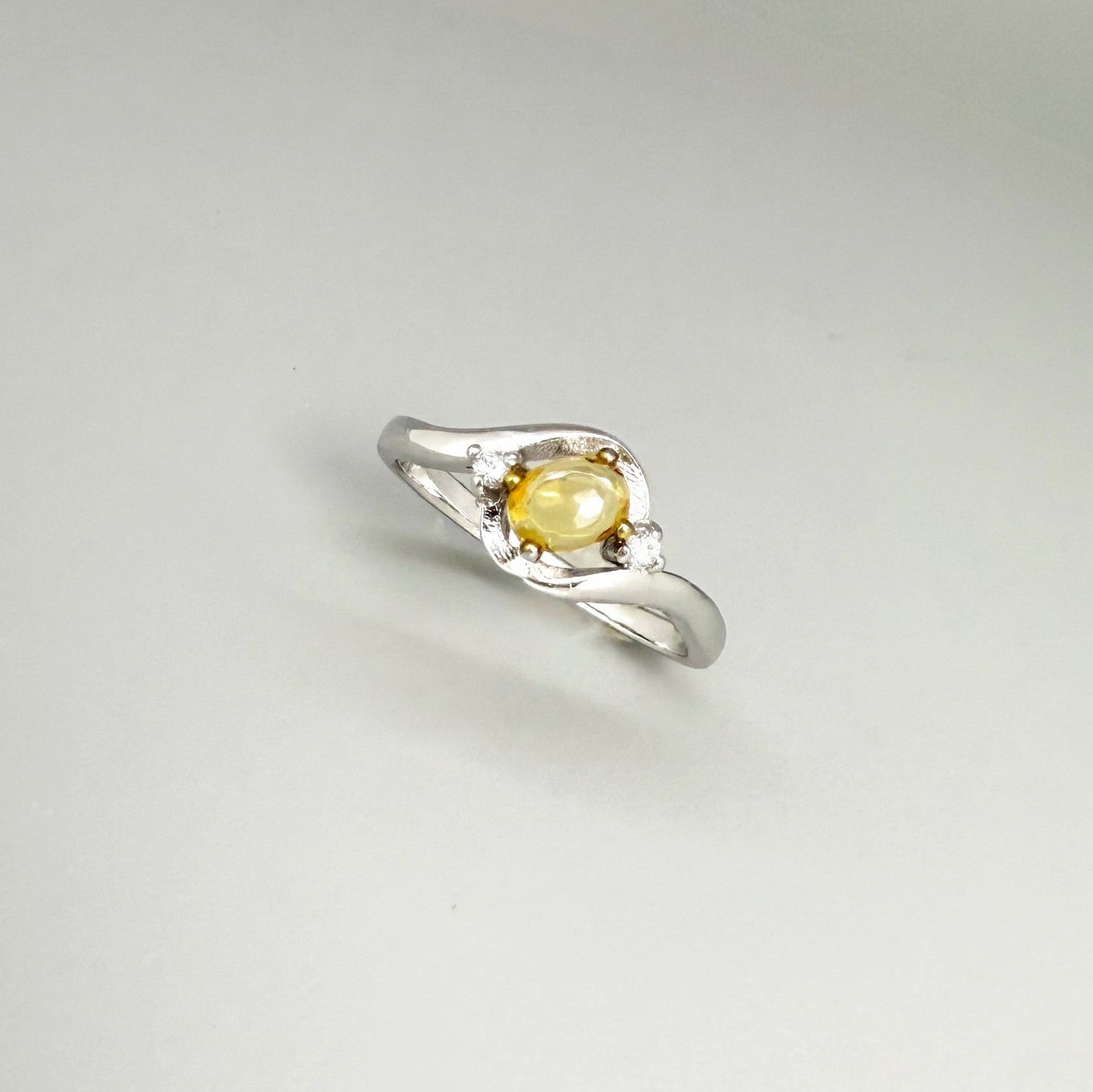 Opal solitaire ring in white gold plated sterling silver, featuring a natural gemstone with yellow hues, elegant and timeless design.