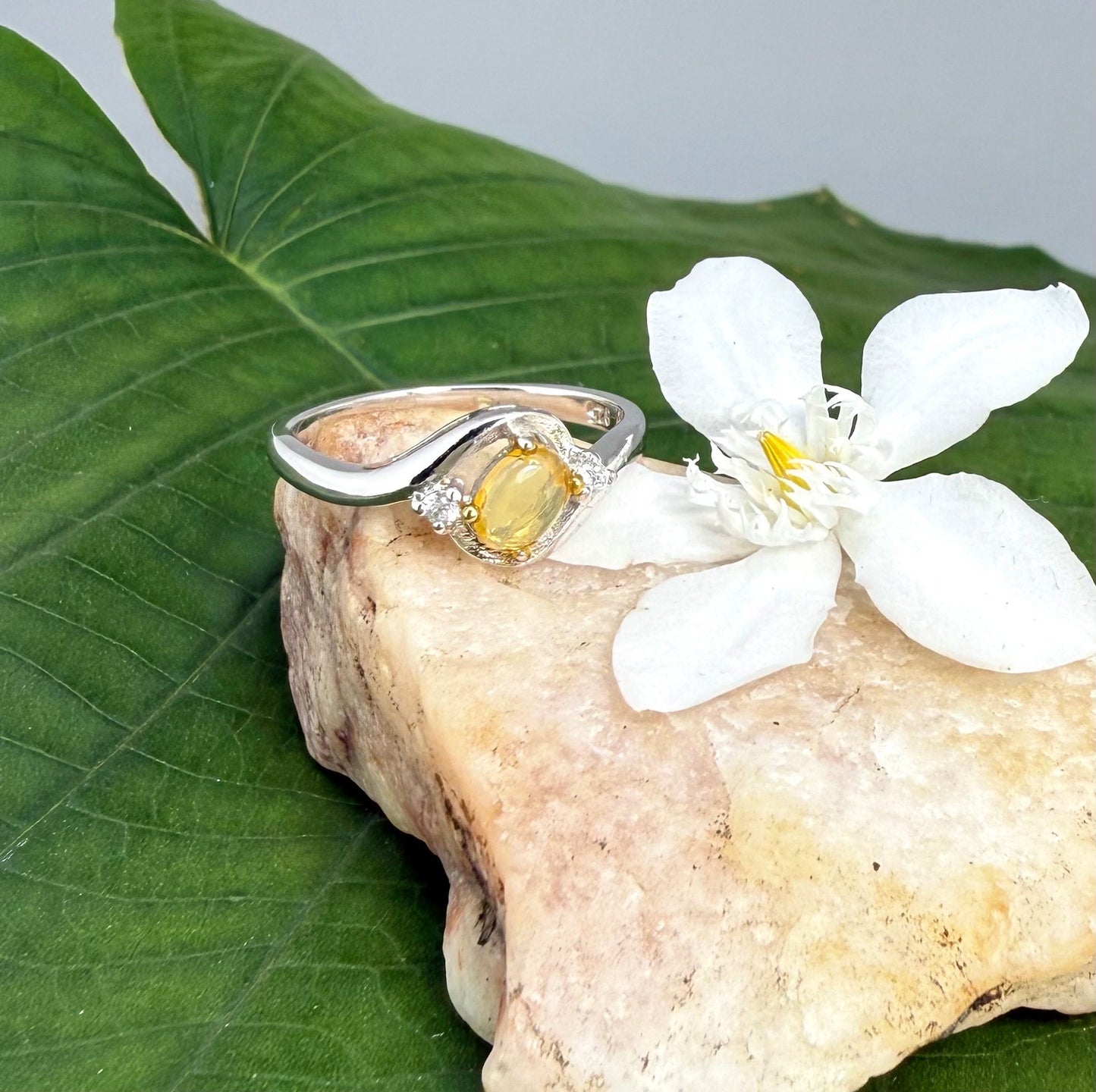 Opal solitaire ring in white gold plated sterling silver, featuring a natural gemstone with yellow hues, elegant and timeless design.