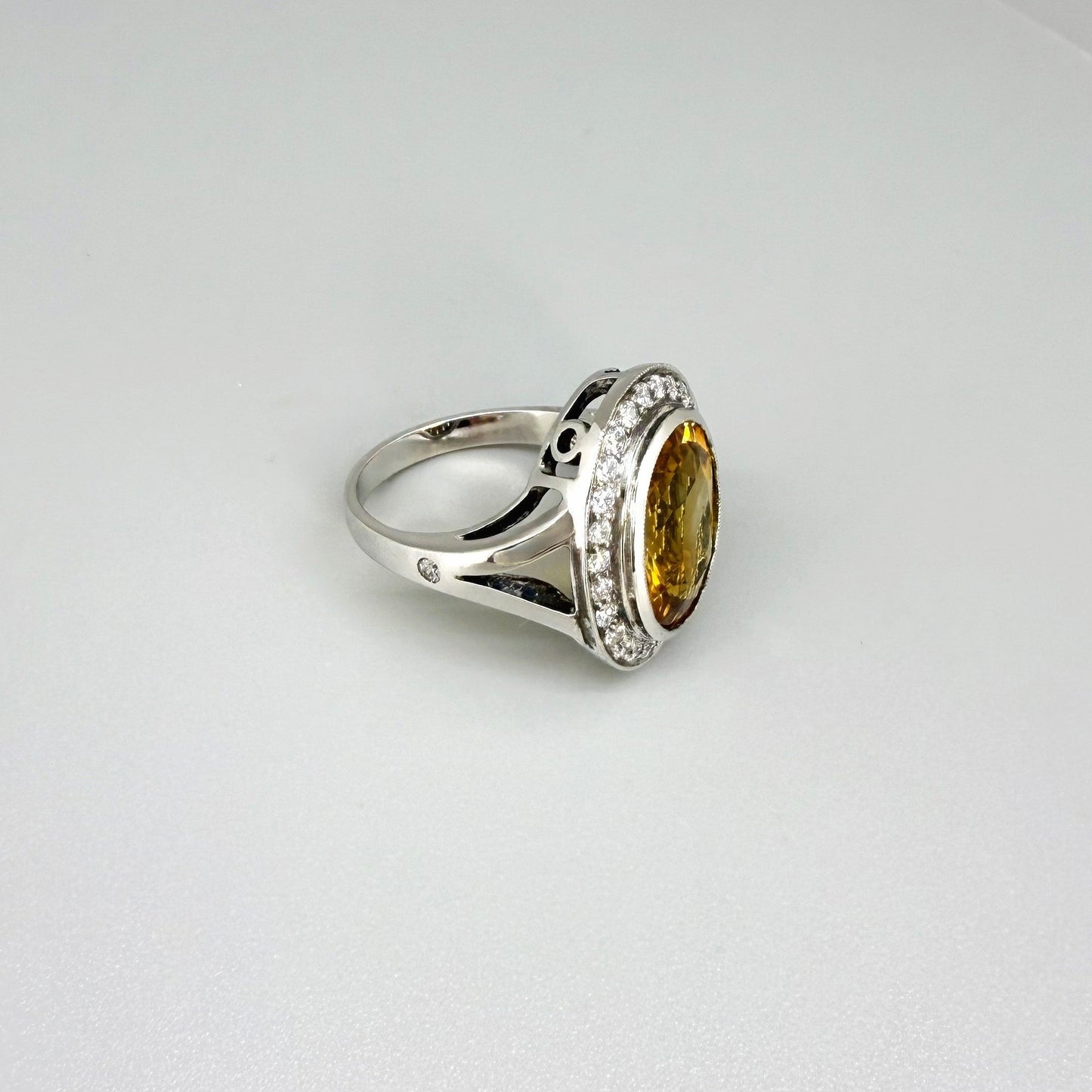 Citrine and CZ ring in white gold plated sterling silver, featuring a faceted golden-yellow gemstone surrounded by clear cubic zirconia halo, elegant and bright design.