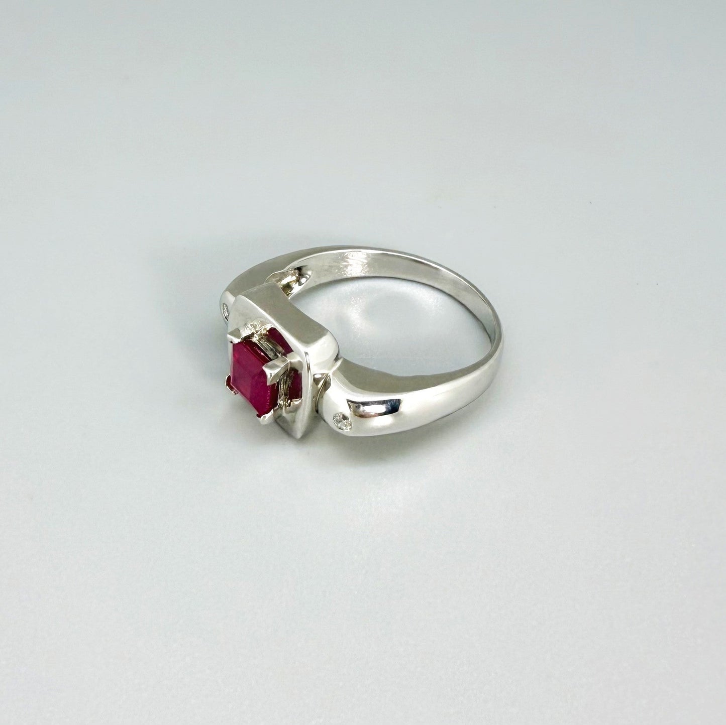 Ruby and CZ ring in white gold plated sterling silver, featuring a vivid red natural ruby framed by clear cubic zirconia, elegant and classic design.