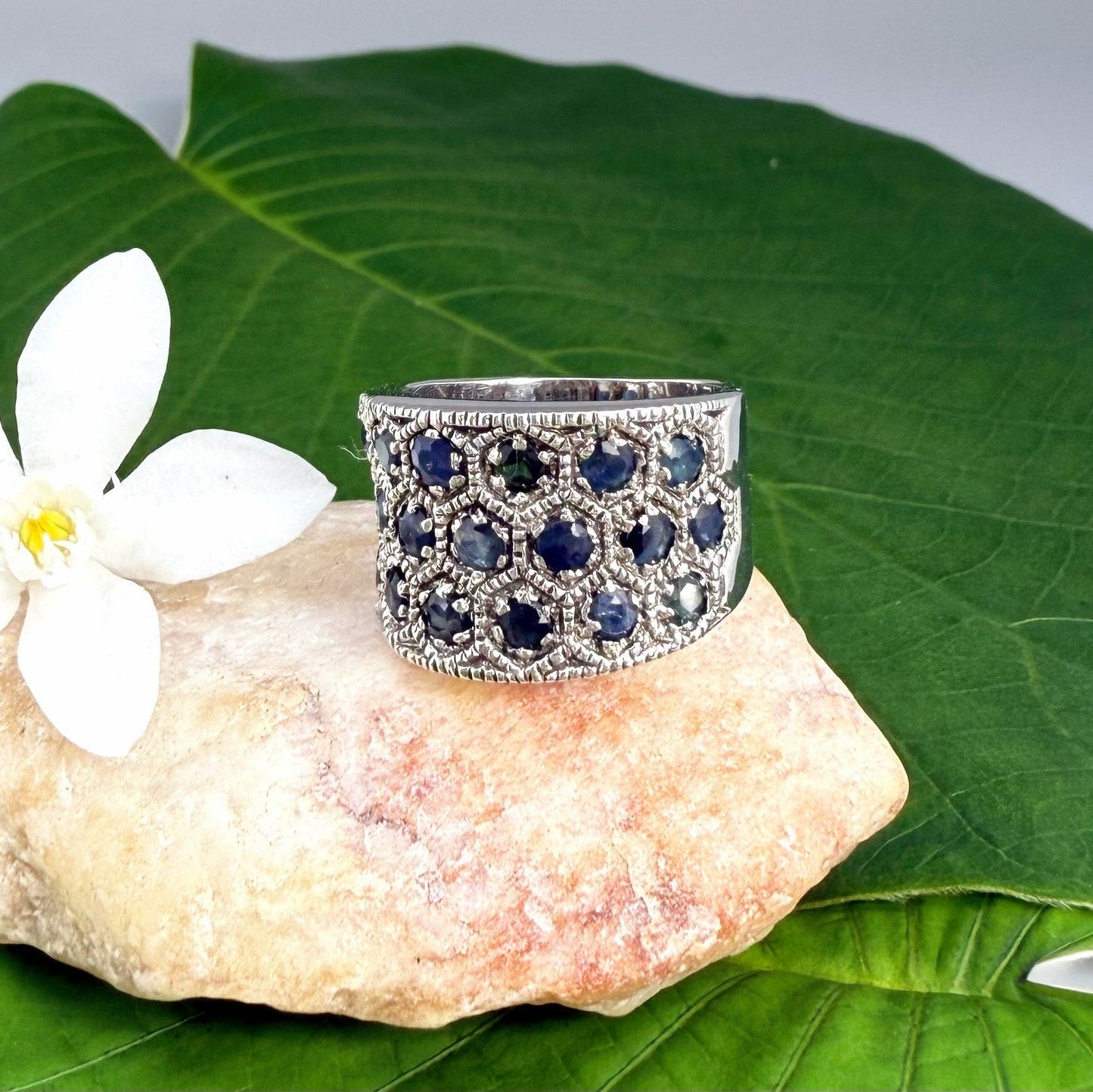Wide band ring with light blue sapphires set in white gold plated sterling silver, reflecting soft blue brilliance with timeless elegance.