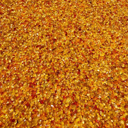 Natural sapphire rough with warm yellow-orange hues and subtle color variation, uncut corundum photographed on neutral background.