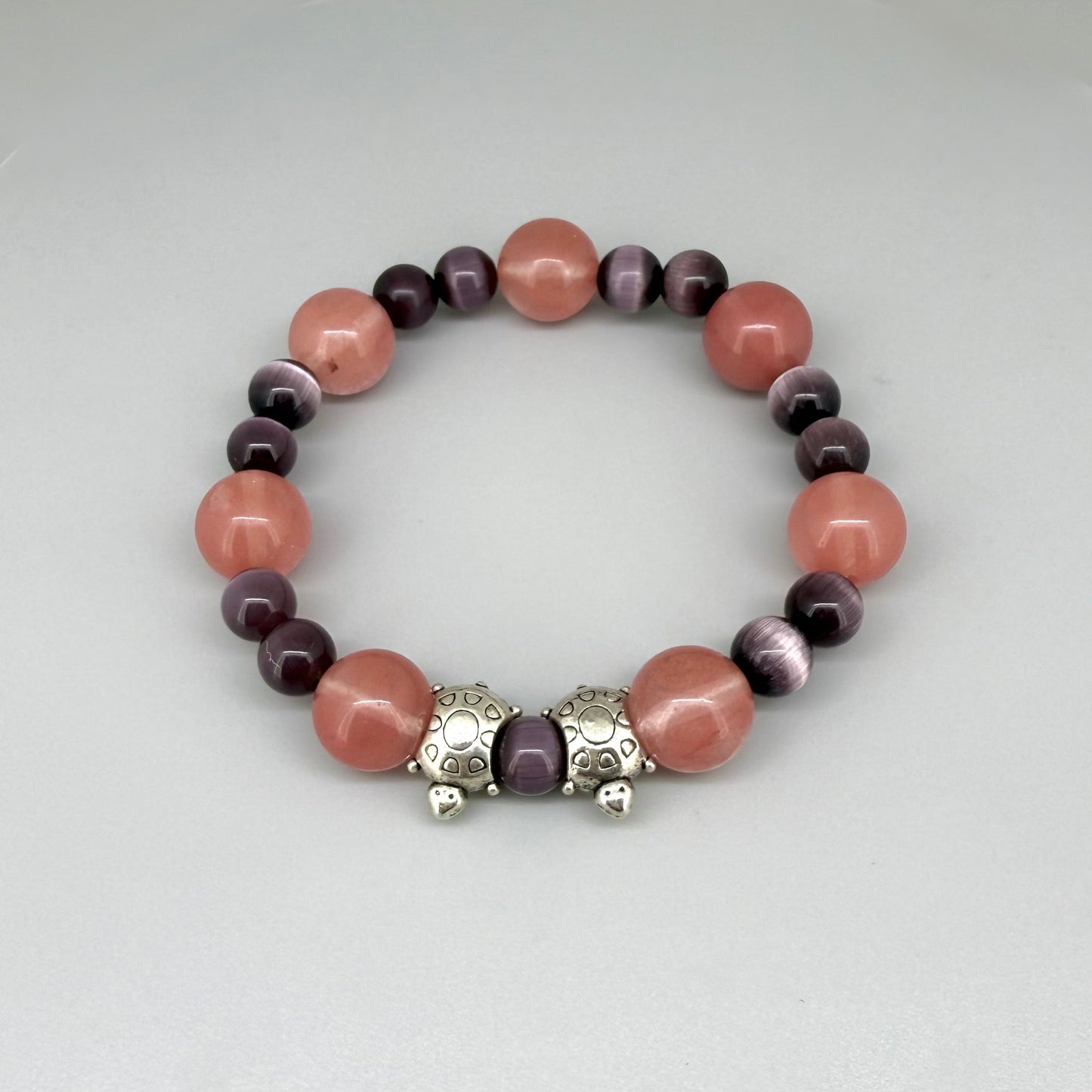 Cherry quartz and cat’s eye beaded bracelet, 18cm, pink and shimmering gemstone beads with two turtle accents on elastic stretch band.