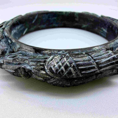 Carved dark jade-style bangle with sculptural relief details and polished surface, 19 cm inner circumference