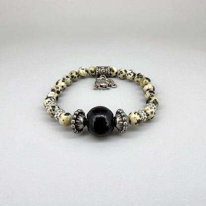 Dalmatian jasper beaded bracelet, 17cm, cream with black speckled gemstone beads and one large black accent bead on elastic stretch band.