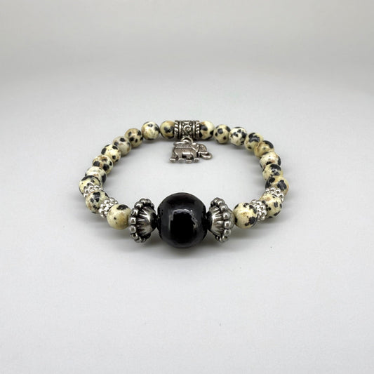 Dalmatian jasper beaded bracelet, 17cm, cream with black speckled gemstone beads and one large black accent bead on elastic stretch band.