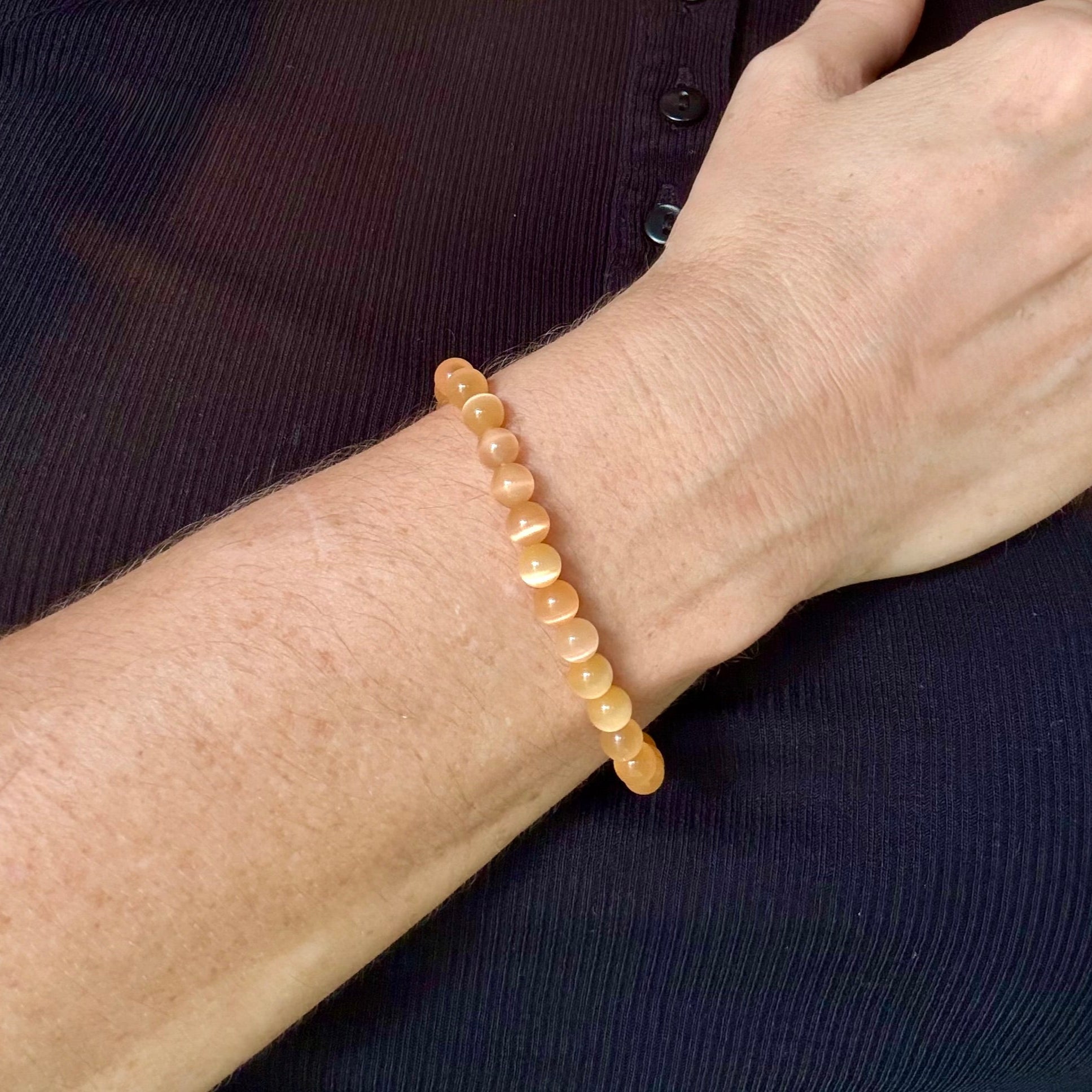 Cat’s Eye beaded bracelet, peach-orange gemstone beads with shimmering light effect on elastic stretch band.