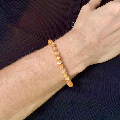 Cat’s Eye beaded bracelet, peach-orange gemstone beads with shimmering light effect on elastic stretch band.