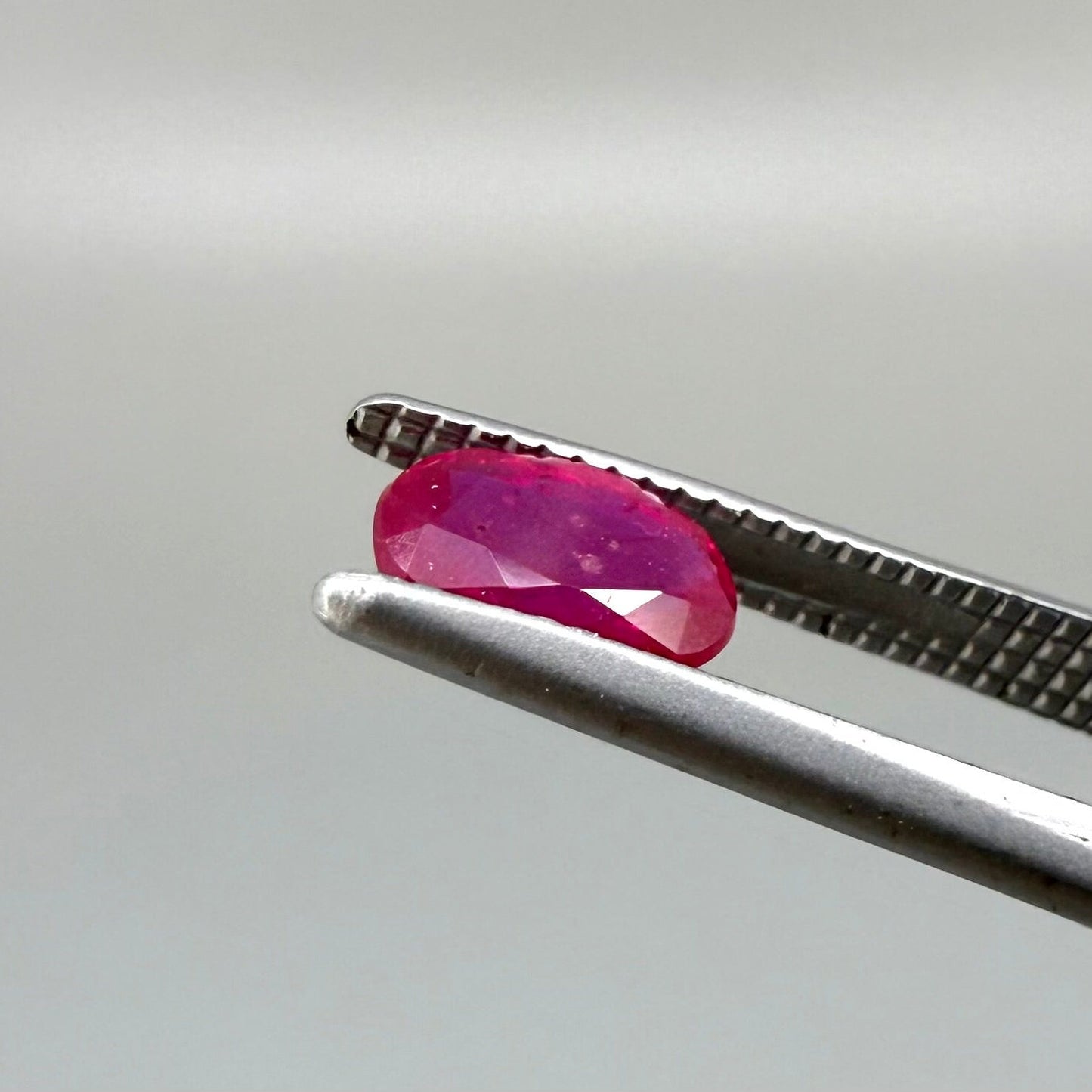 0.6 ct natural Songea ruby, oval cut in a pink-red tone.