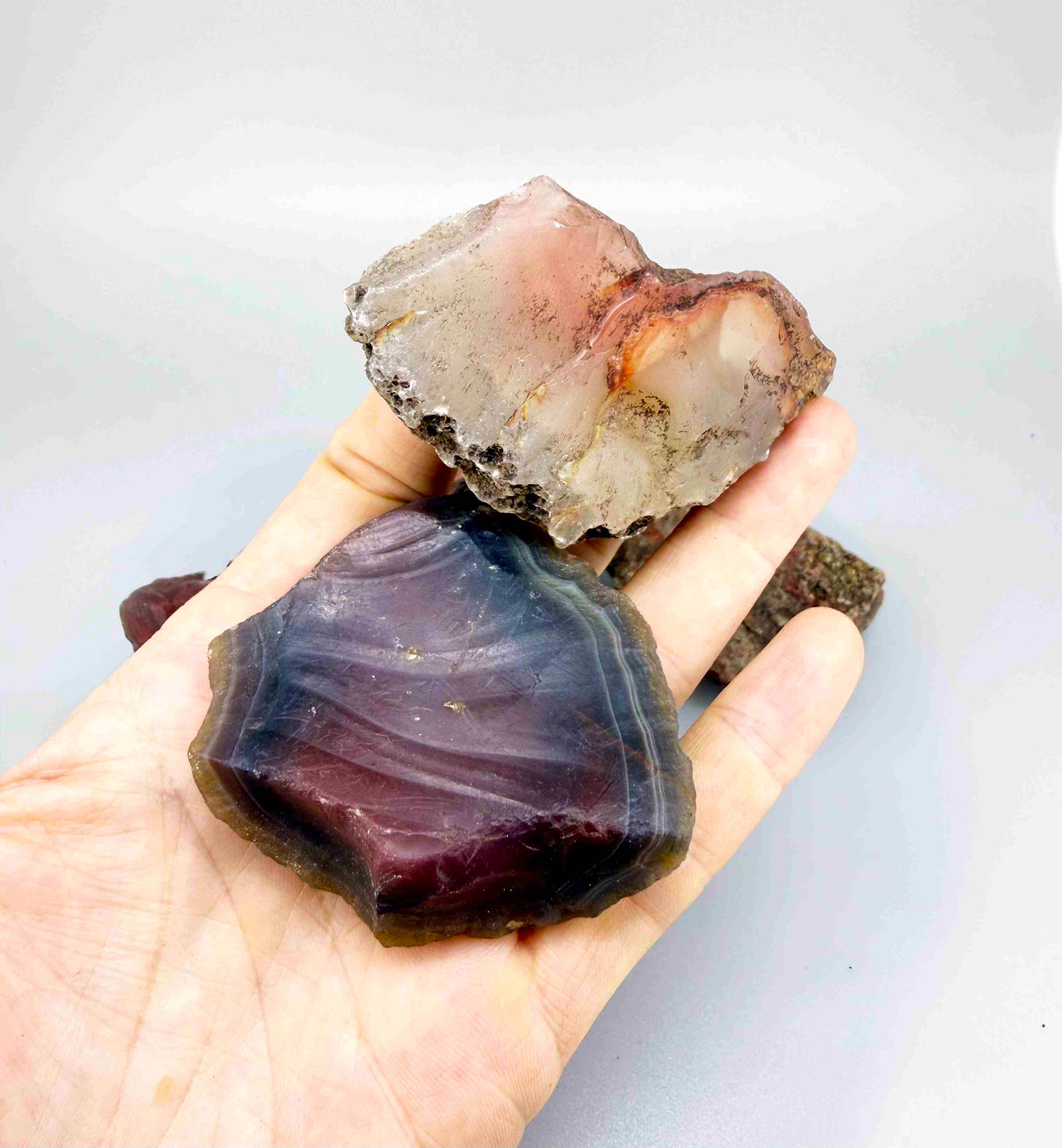 Natural chalcedony / carnelian rough lot in warm orange and red hues, uncut quartz material.