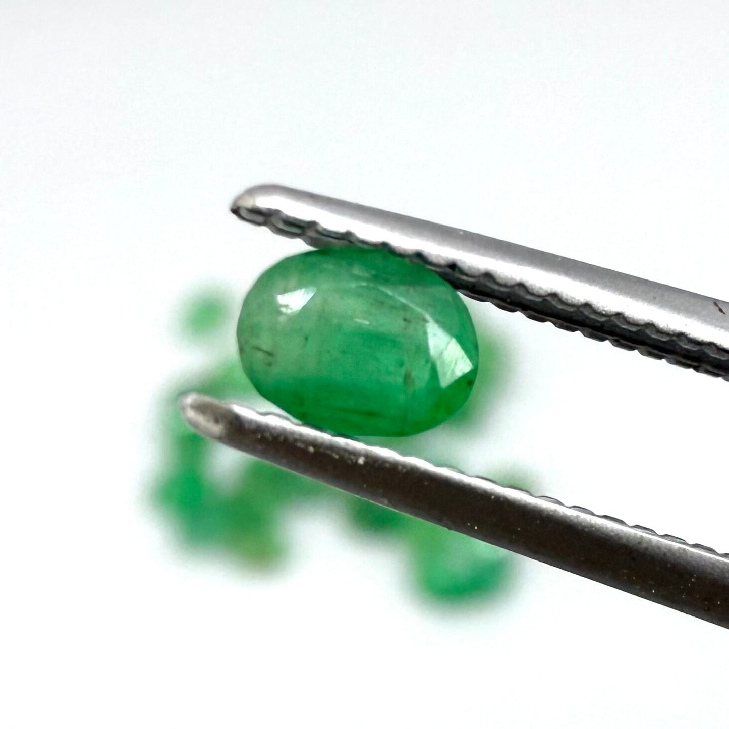 5.5 ct natural untreated Zambian emerald lot, faceted oval stones with vivid bluish-green color.