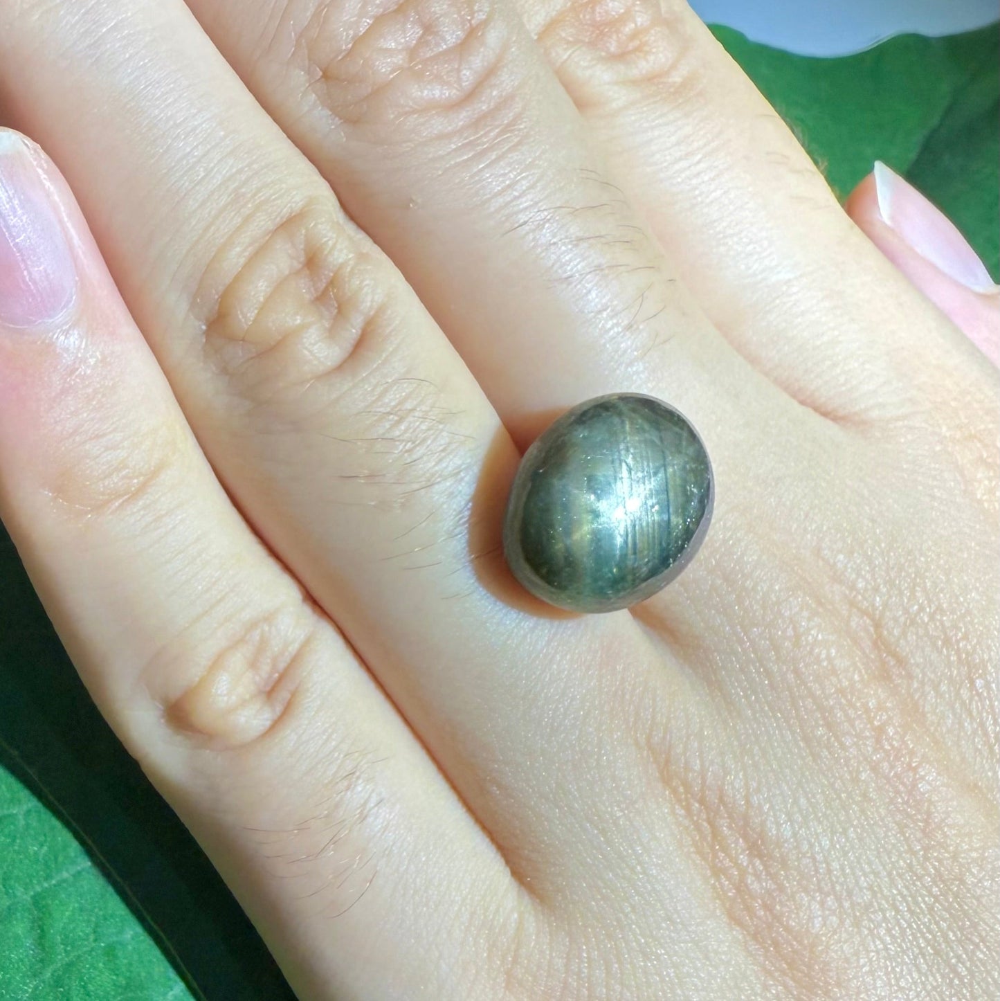 Golden-brown star sapphire cabochon, natural gemstone with visible asterism