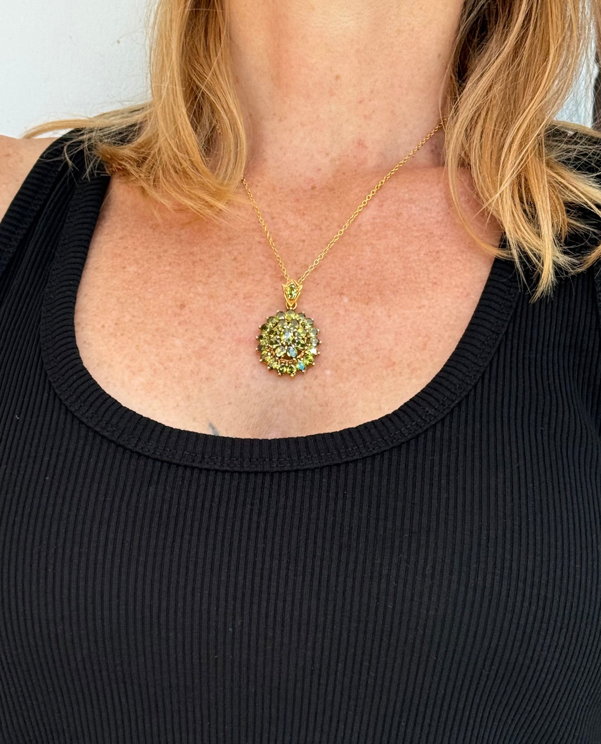 Gold-plated sterling silver pendant with natural green sapphires in a floral-inspired design.