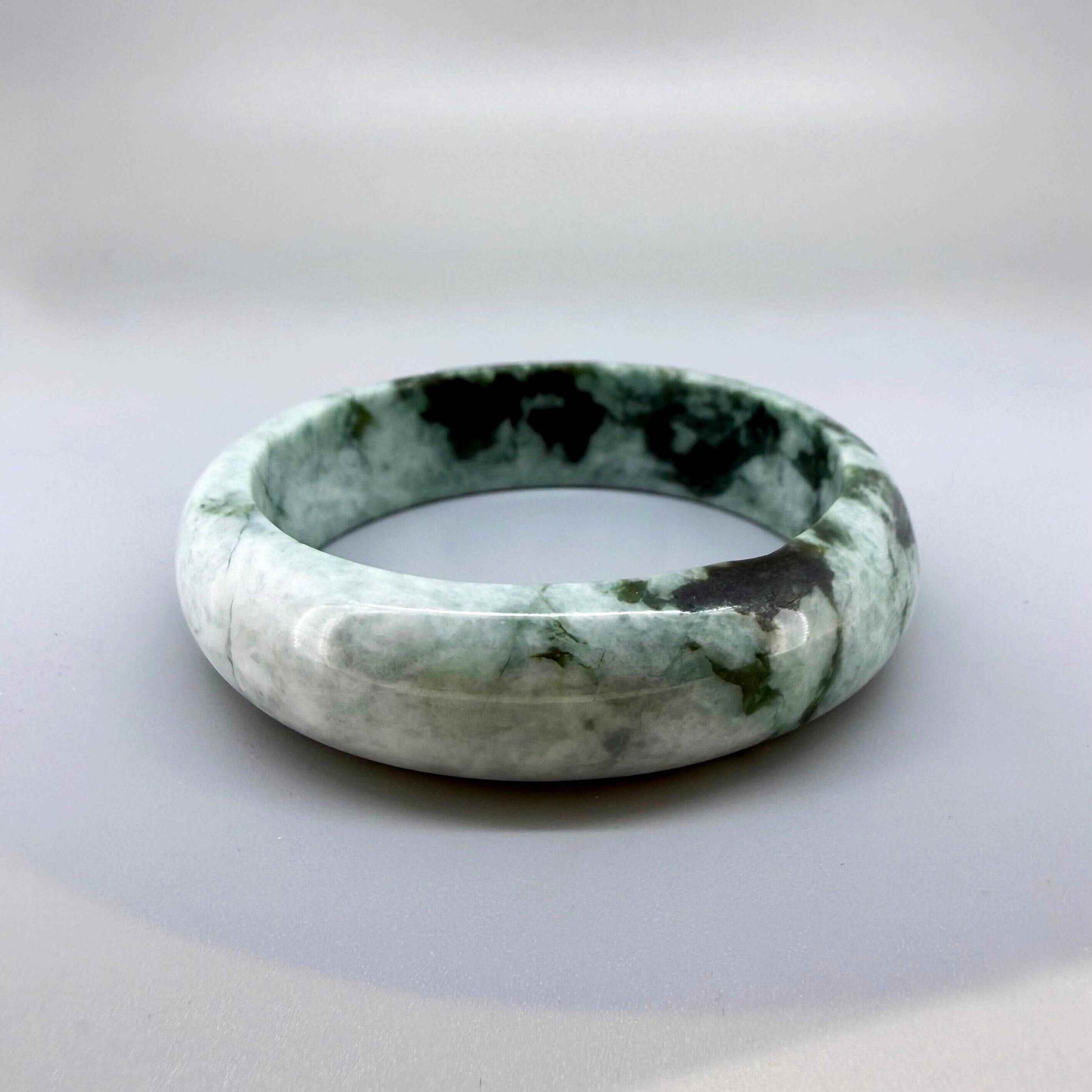 Polished jade bangle in soft green hues with smooth surface and natural variations, 20 cm inner circumference