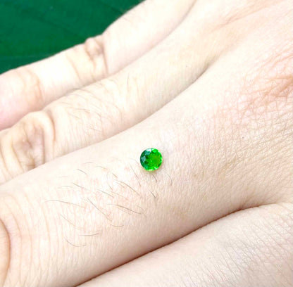 0.22 ct natural grass-green diopside, round cut with intense color.