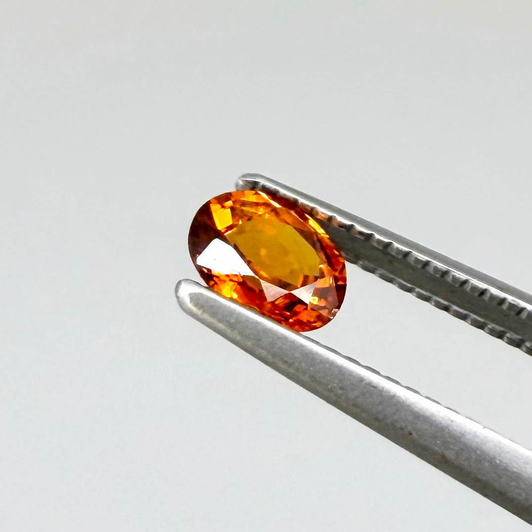 0.56 ct natural spessartine garnet from Namibia, fiery orange, faceted.