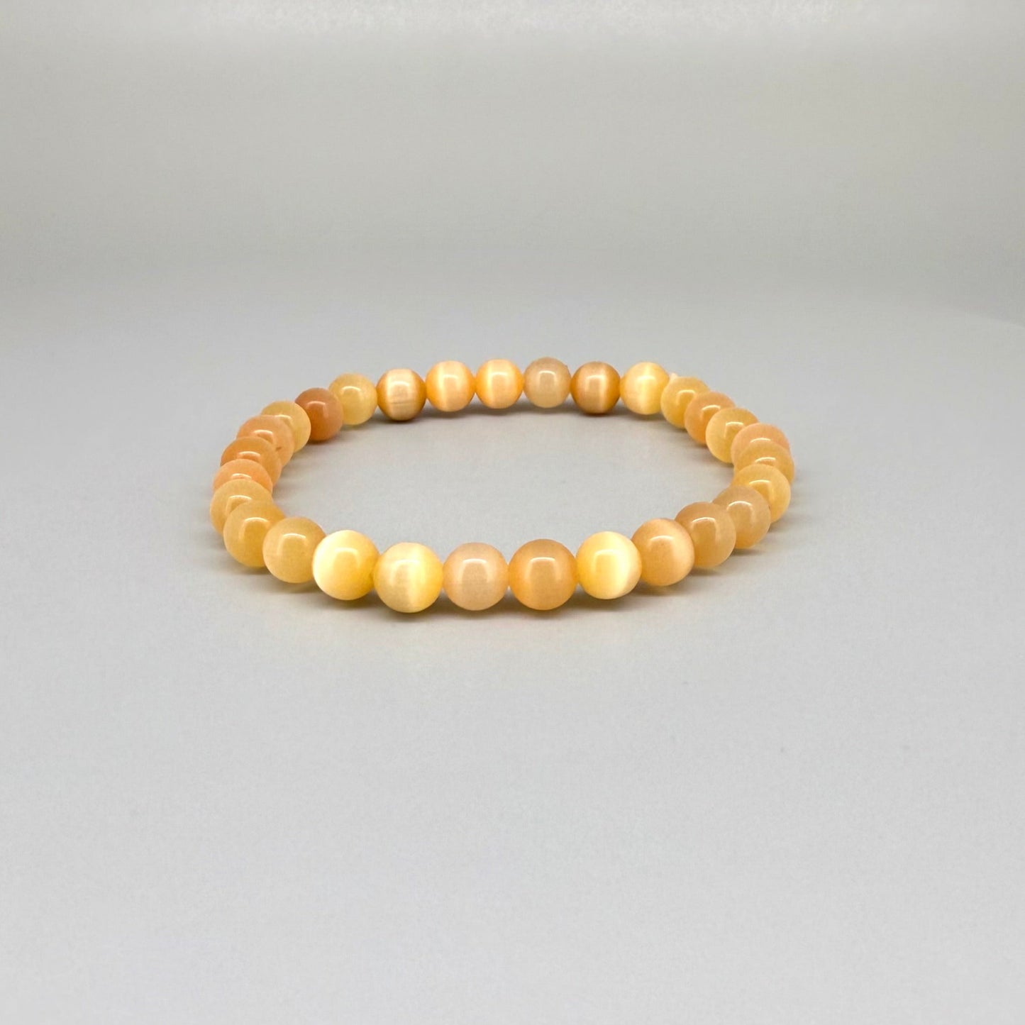 Cat’s Eye beaded bracelet, peach-orange gemstone beads with shimmering light effect on elastic stretch band.