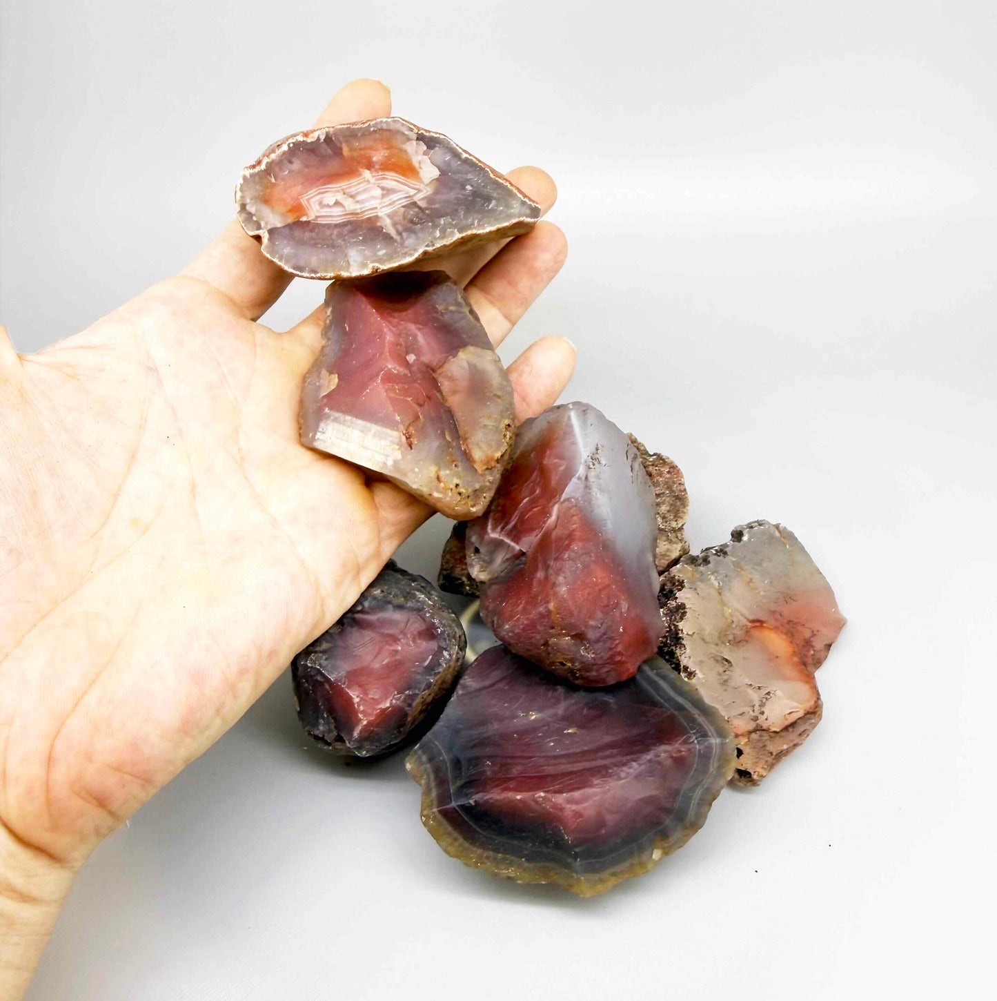 Natural chalcedony / carnelian rough lot in warm orange and red hues, uncut quartz material.