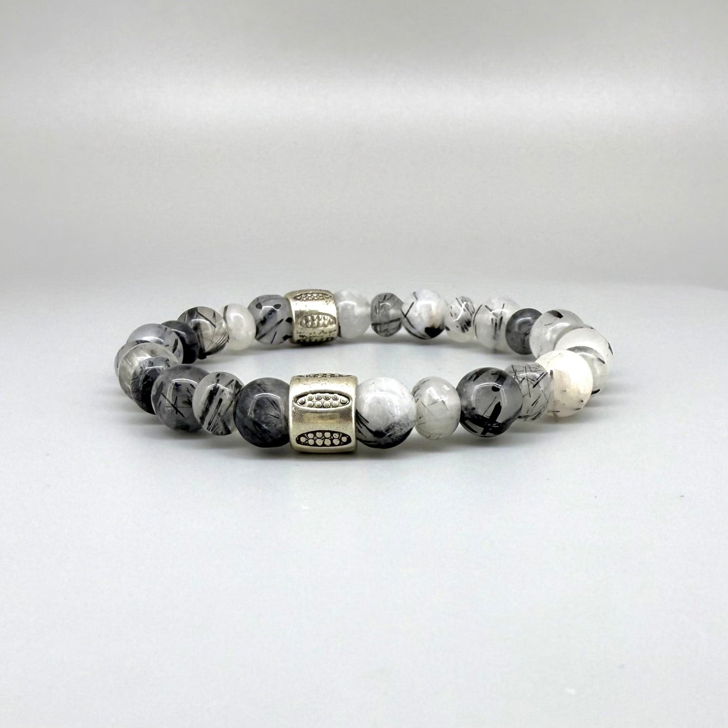 Rutilated quartz beaded bracelet, 18cm, black-white-grey gemstone beads with two decorated metal spacers on elastic band.