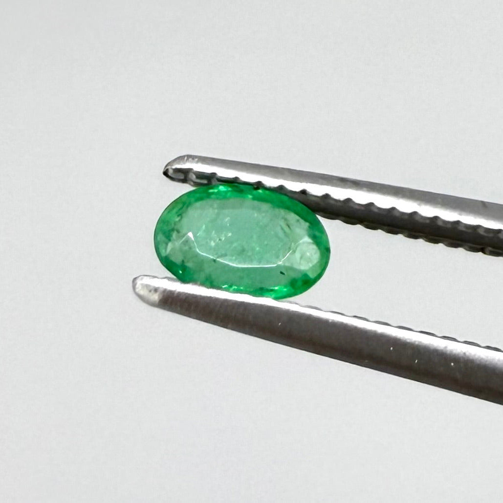 0.16 ct natural untreated Zambian emerald, oval faceted with vivid bluish-green color.