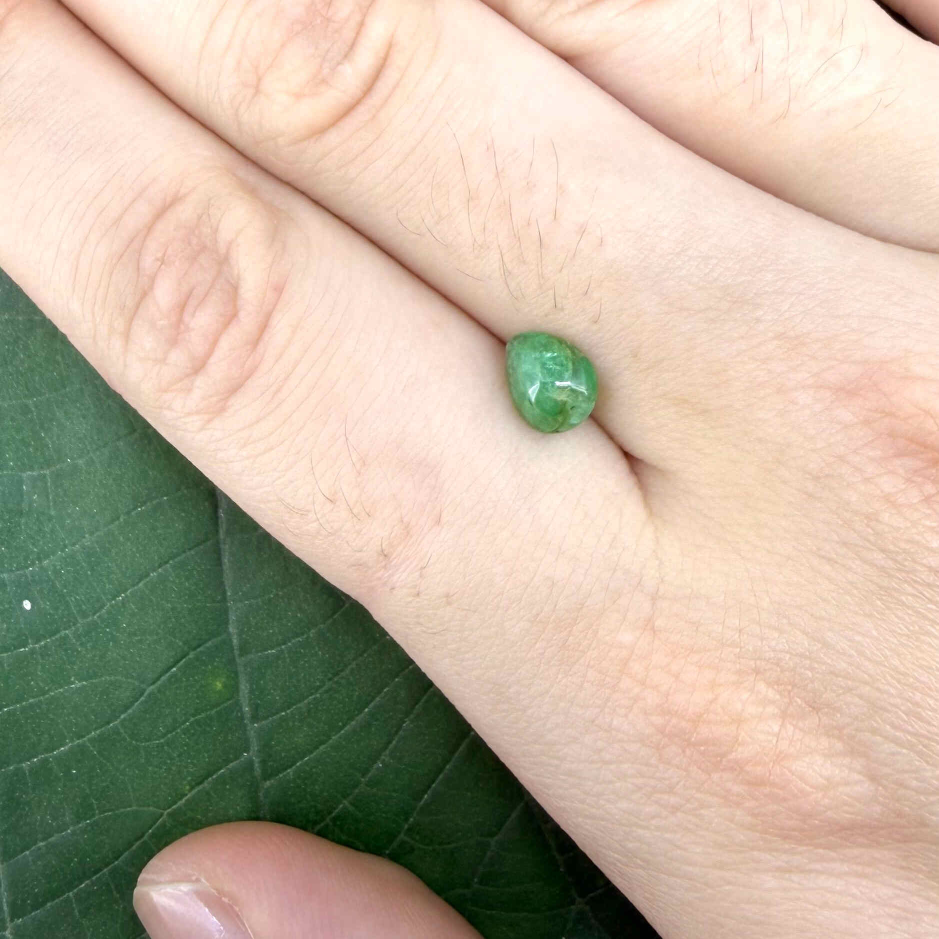 0.75 ct natural untreated emerald from Zambia, one side polished and the other cabochon-shaped.