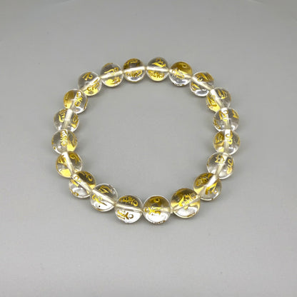 Clear quartz beaded bracelet, 19cm, transparent gemstone beads engraved with golden Sanskrit mantra Om Mani Padme Hum on elastic stretch band.