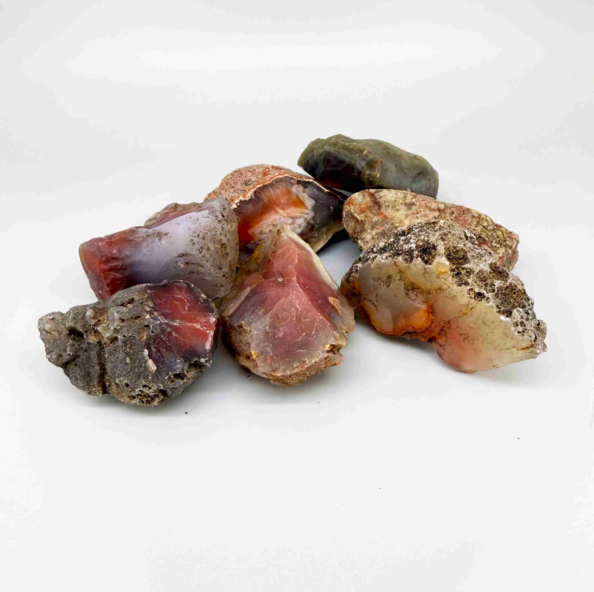 Natural chalcedony / carnelian rough lot in warm orange and red hues, uncut quartz material.