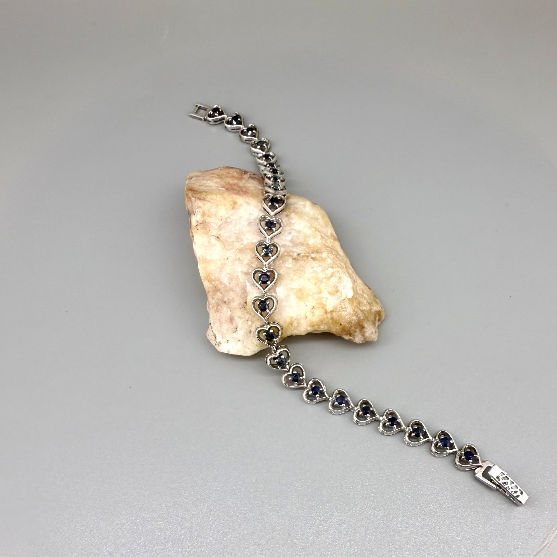 Sapphire bracelet in sterling silver with white gold plating, elegant design on neutral background