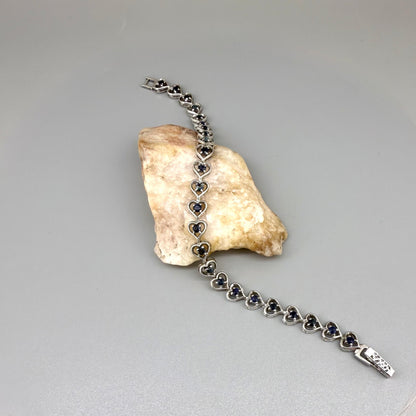 Sapphire bracelet in sterling silver with white gold plating, elegant design on neutral background