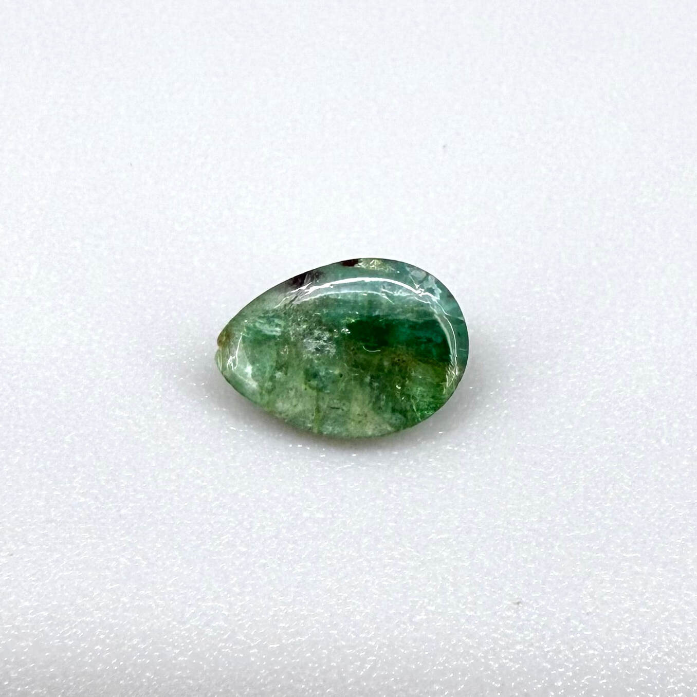1.42 ct natural untreated emerald from Zambia, one side polished and the other cabochon-shaped.