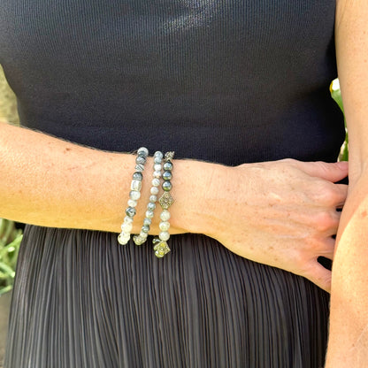 Rutilated quartz beaded bracelet, 18cm, black-white-grey gemstone beads with two decorated metal spacers on elastic band.